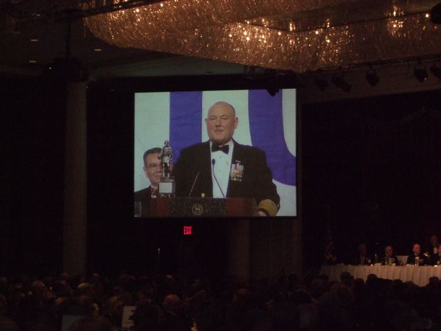 the video screen is showing a picture of two men in tuxedo