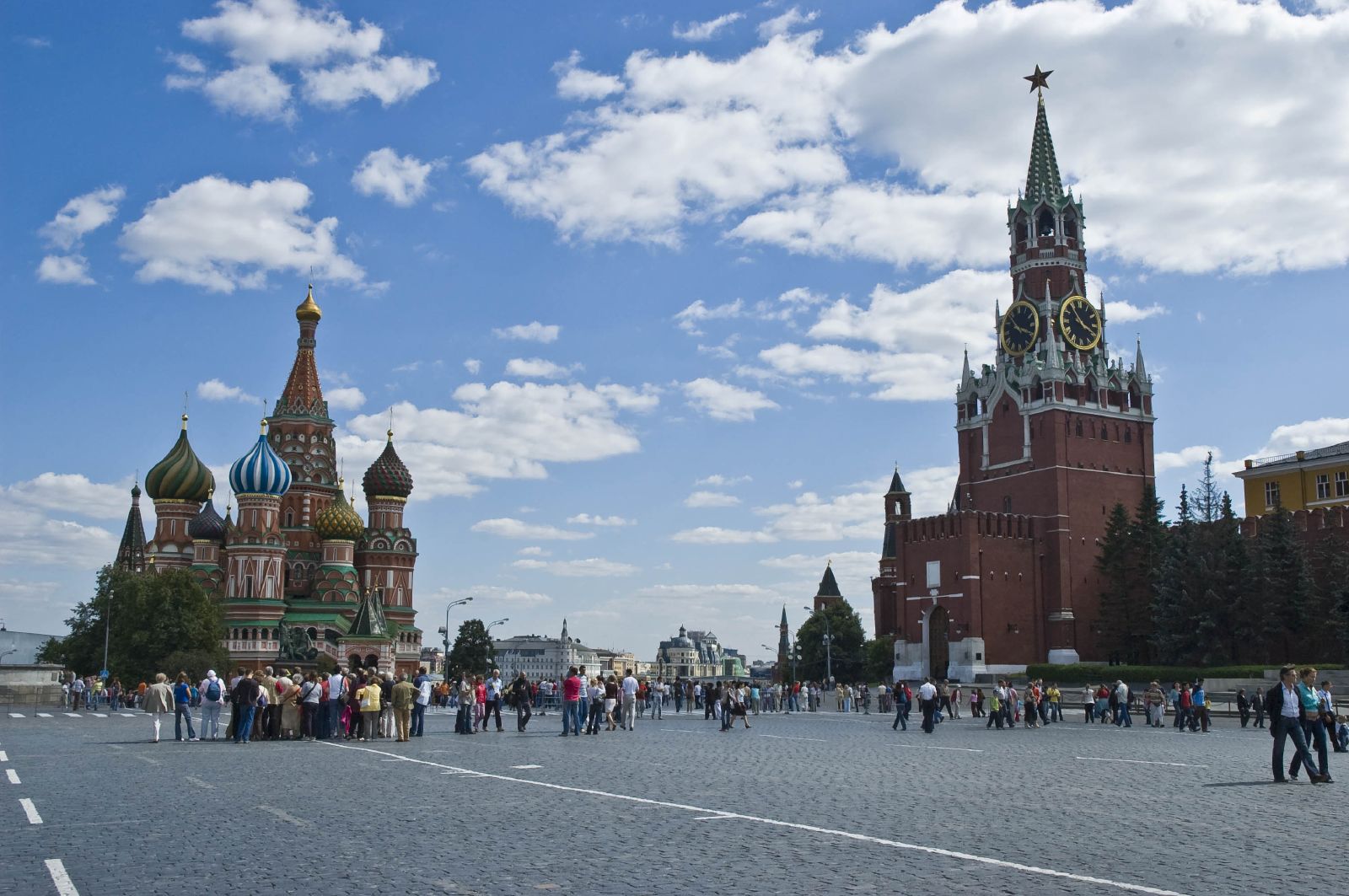 many people stand near the cathedral under a blue sky