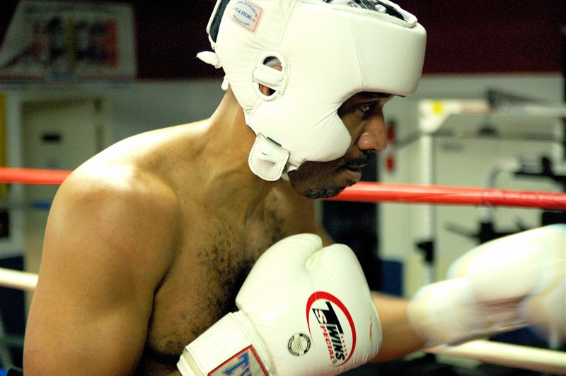 a boxer wearing boxing gear preparing to kick his opponent