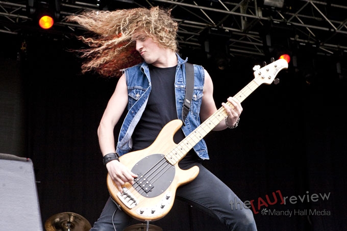 a man playing guitar with long hair at the stage
