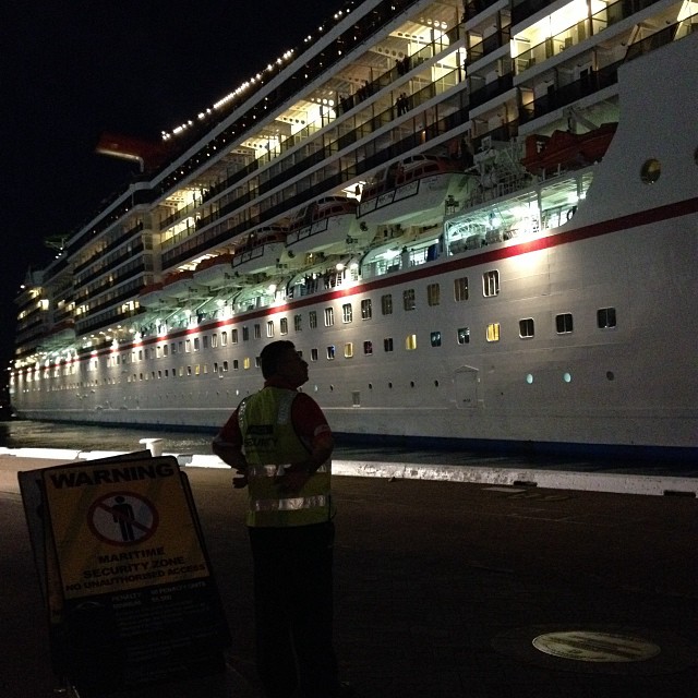 a man is standing next to a cruise ship