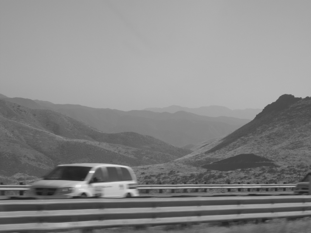 a van driving in front of another car on the road