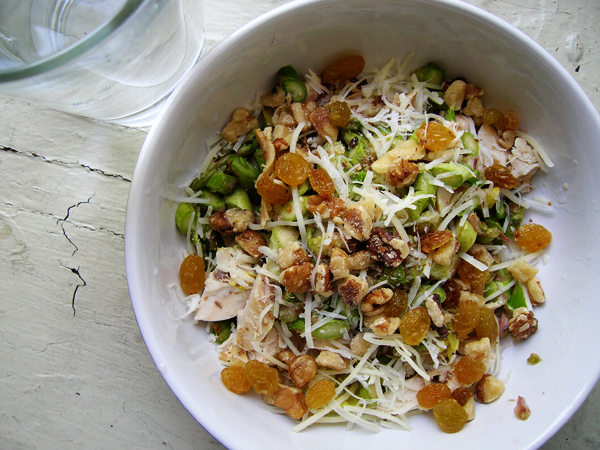 a bowl containing fruit and nuts and shredded cheese
