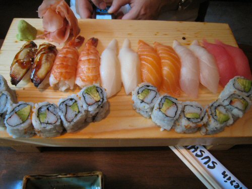 there is sushi on the tray and several other pieces in it