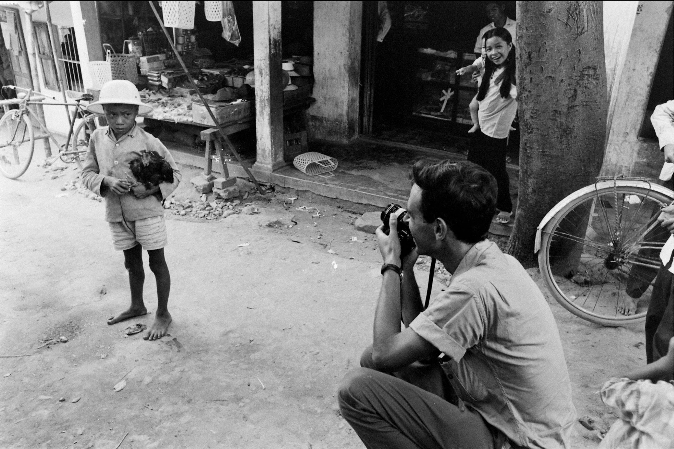 three people standing and one taking pictures