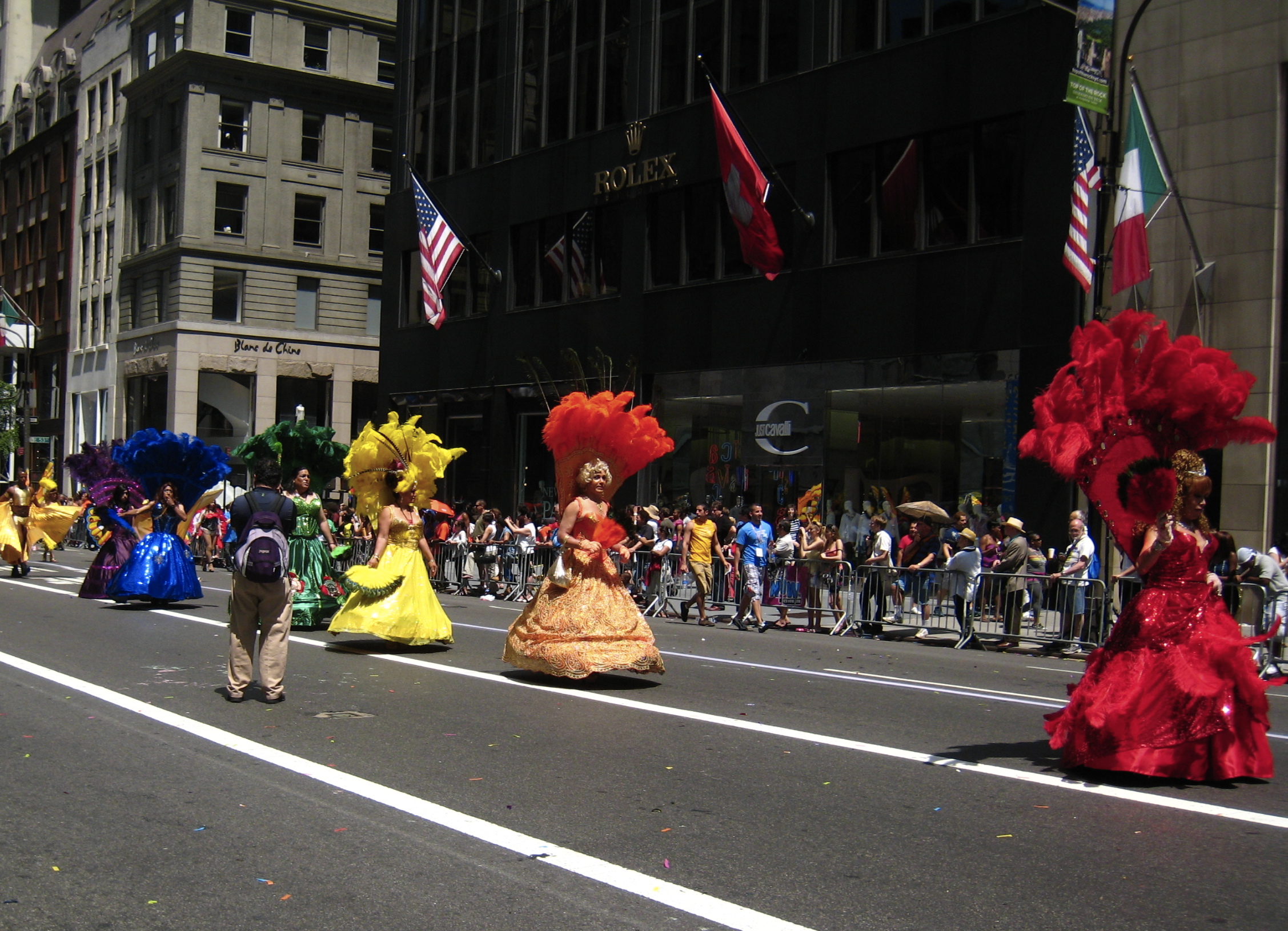 some people wearing colorful costumes are walking down the street