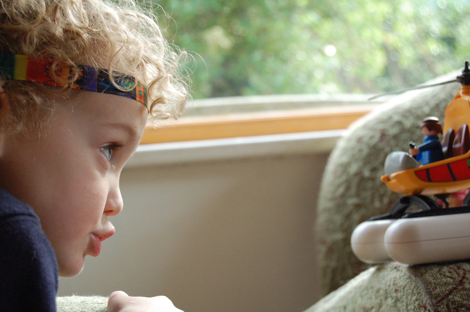 a little boy wearing a headband watching a ship