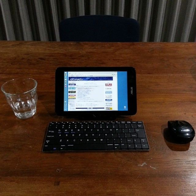 tablet and keyboard displayed on table next to glasses