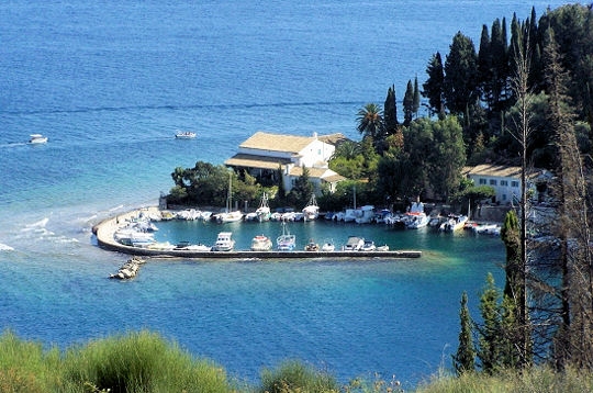 an island with some boats in it surrounded by grass and trees