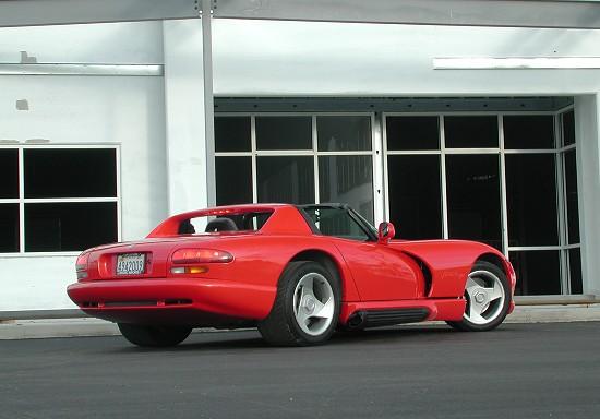 a red sports car is parked near an office building