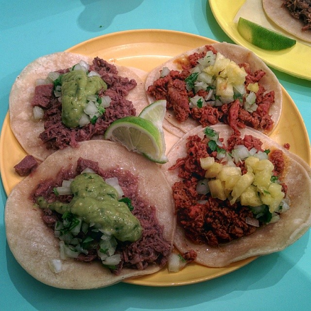 three tacos, including one with various fillings, sitting on a plate
