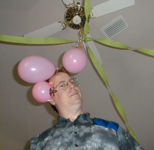 man with glasses looking up under a ceiling fan
