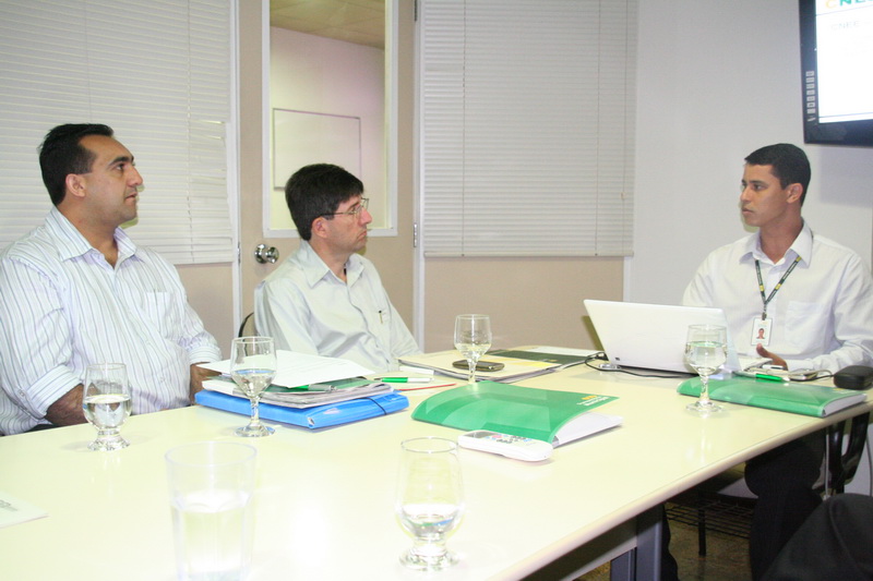 three men sit on desk with laptops on their lap