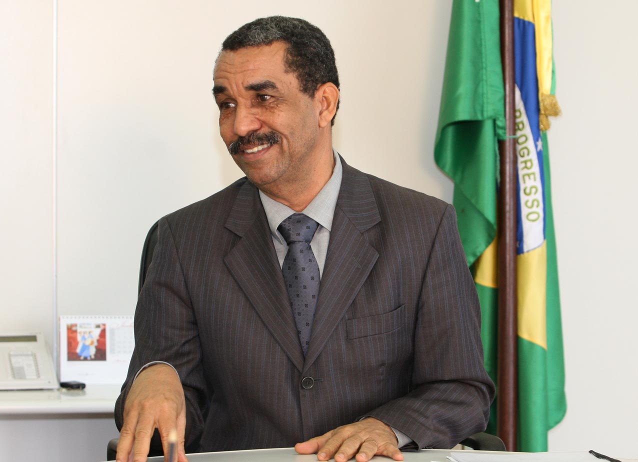 a businessman sits at a desk signing paperwork