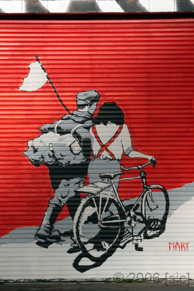 a building that has a painted on on it with an image of two people on a bike