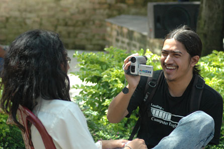 a smiling man holding up a camera to a woman