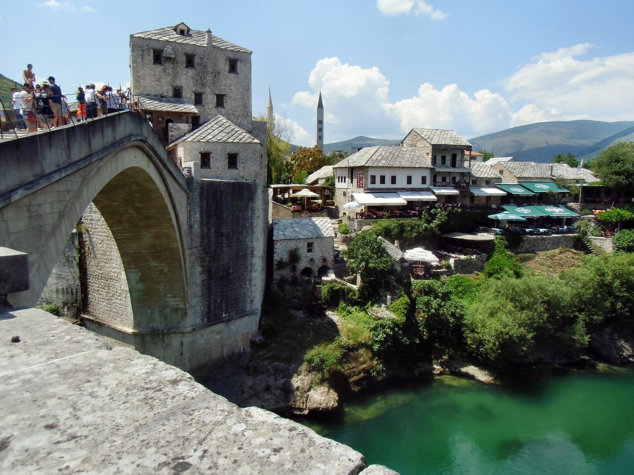 a bridge with people on top next to some water