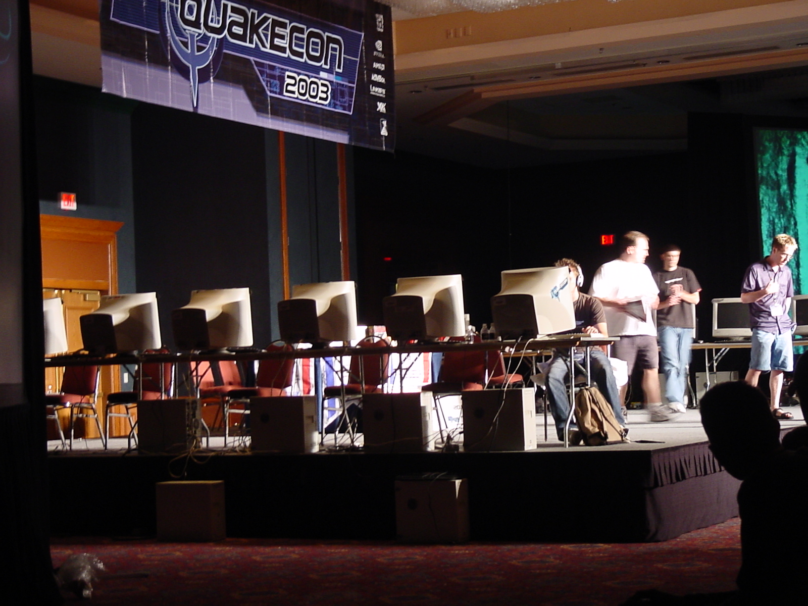 group of men standing on stage in front of large set up speakers