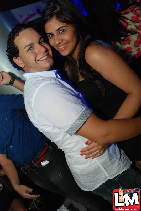 two people posing for the camera in a nightclub