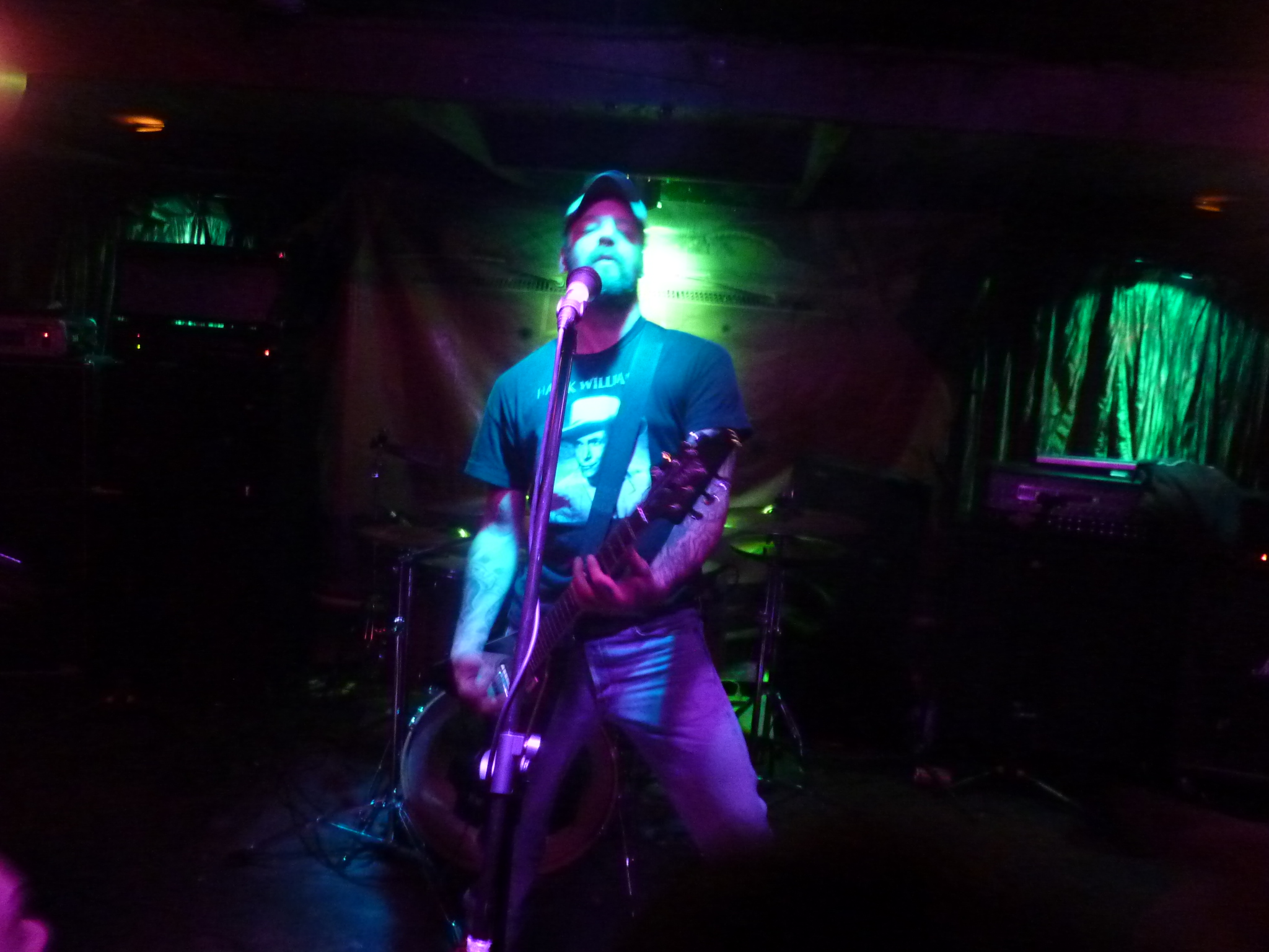 a man with a guitar on a stage with some lights on