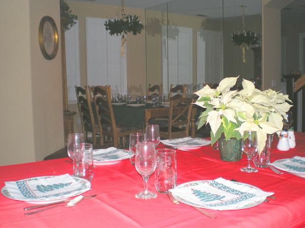 the table in the dining room is set up with plates and place settings
