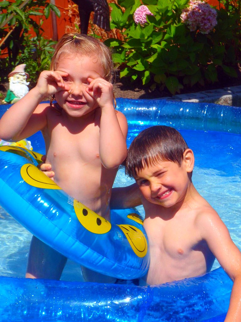 two s playing in the pool with a raft
