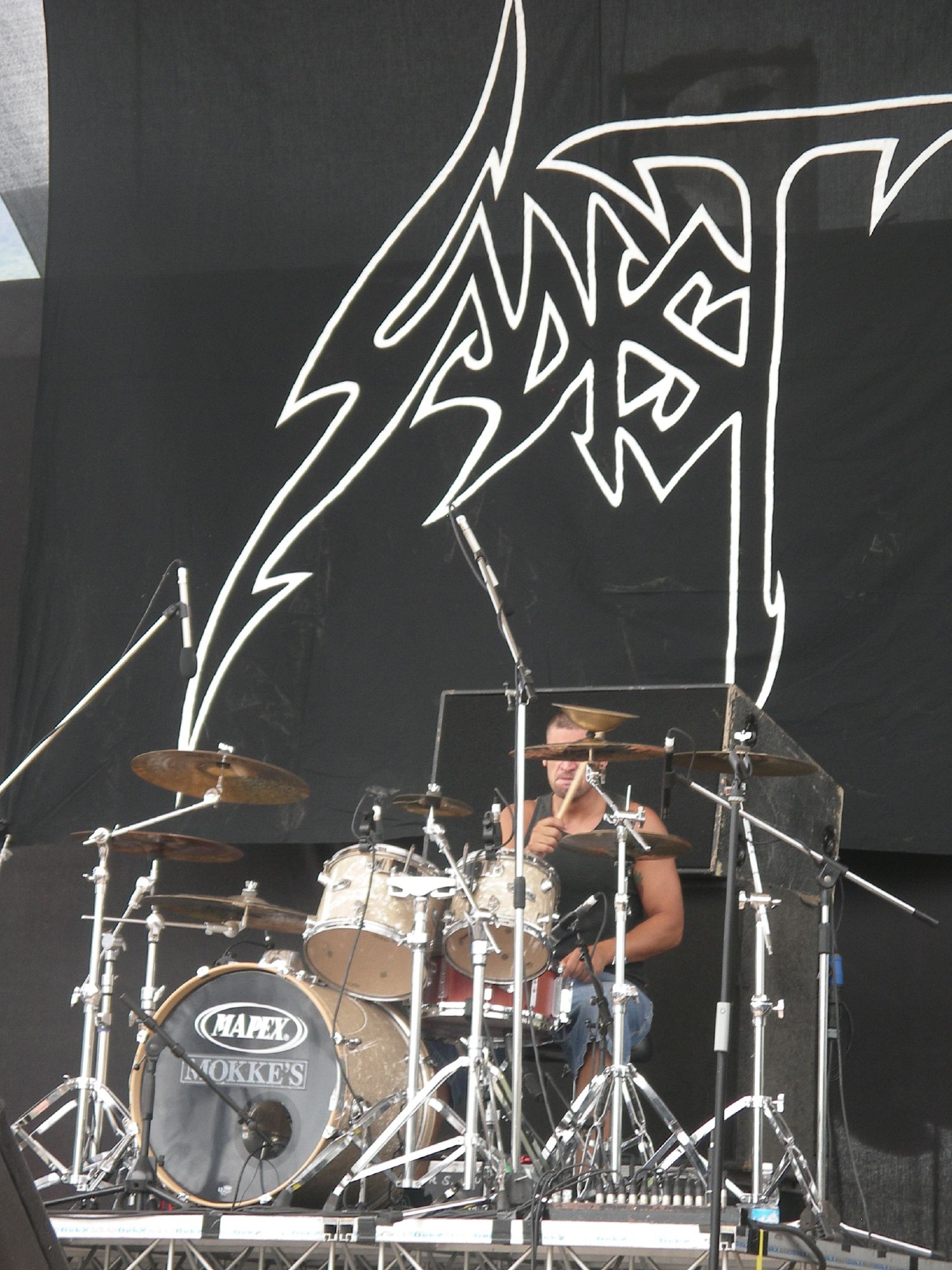 a man on a stage playing drums and a guitar