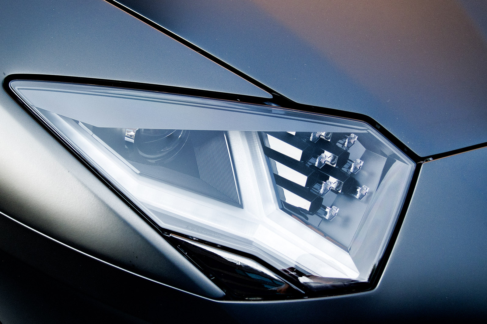 a chrome colored sports car with an image of the front light