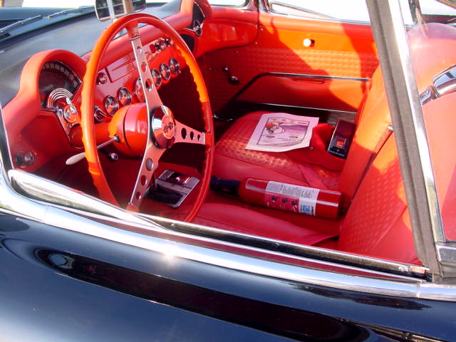 an orange sports car dashboard with the center console and steering wheel