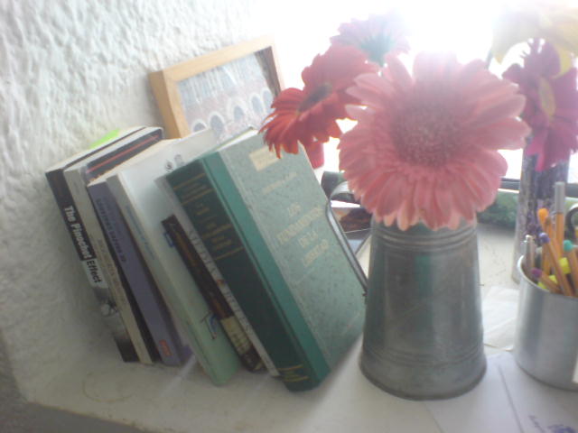 a vase filled with flowers next to a book