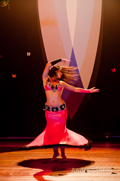 a belly dancer performs at a performance in front of an image of the wall