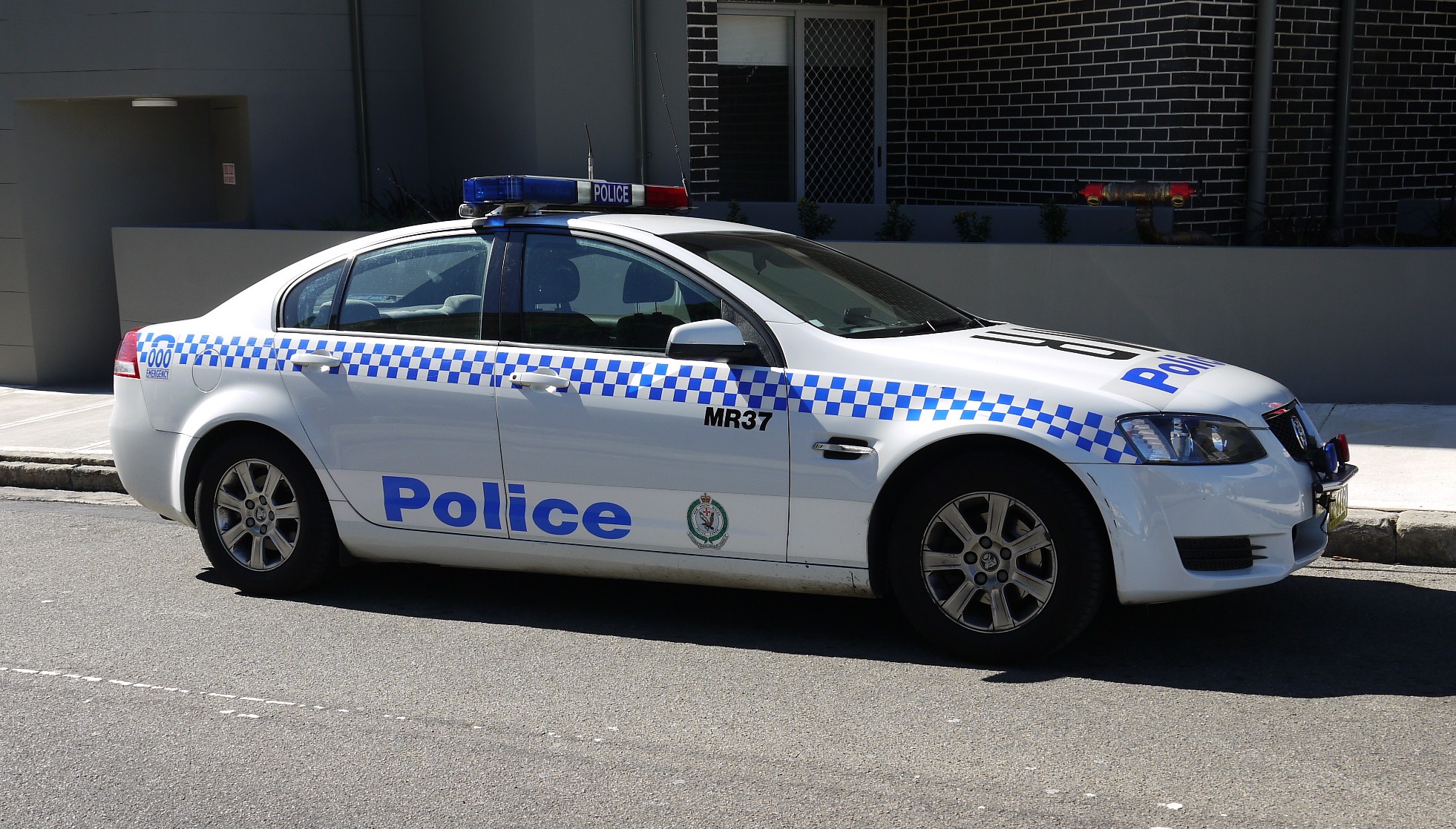 police car with lights on parked next to building