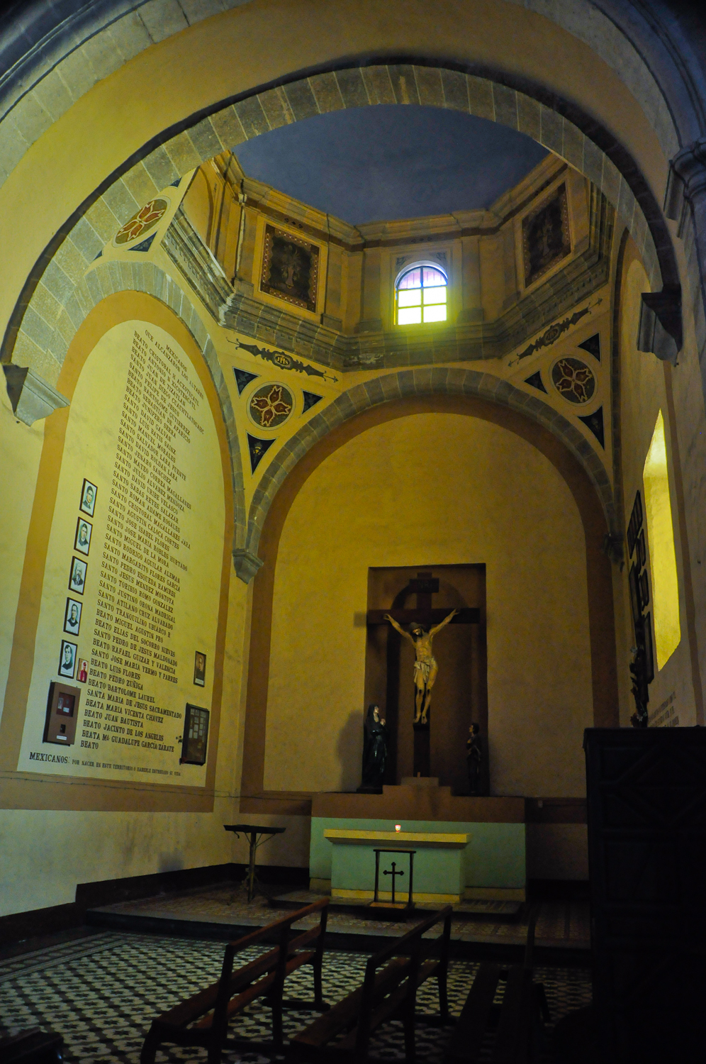 a church with yellow walls and an arch with crucifix in it