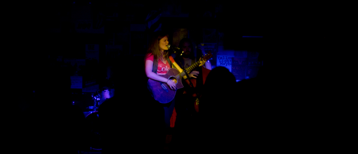 two people playing guitar at the club