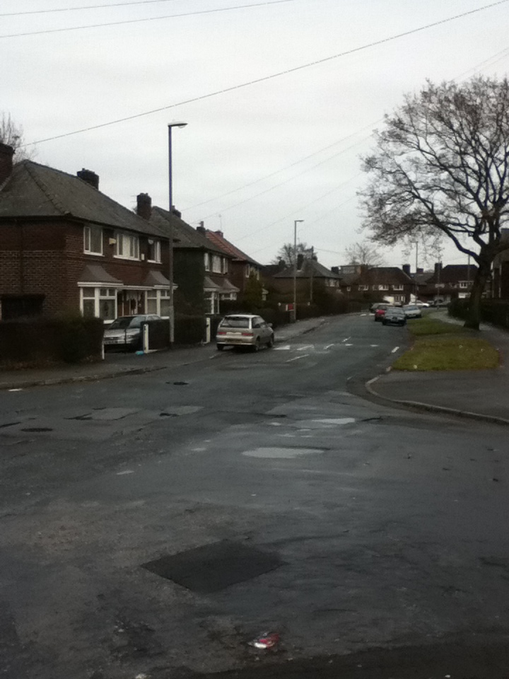 a wet street in the middle of a neighborhood