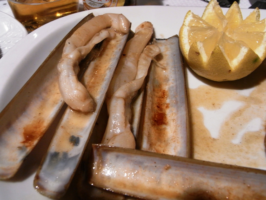 a sausage is next to a lemon on the plate