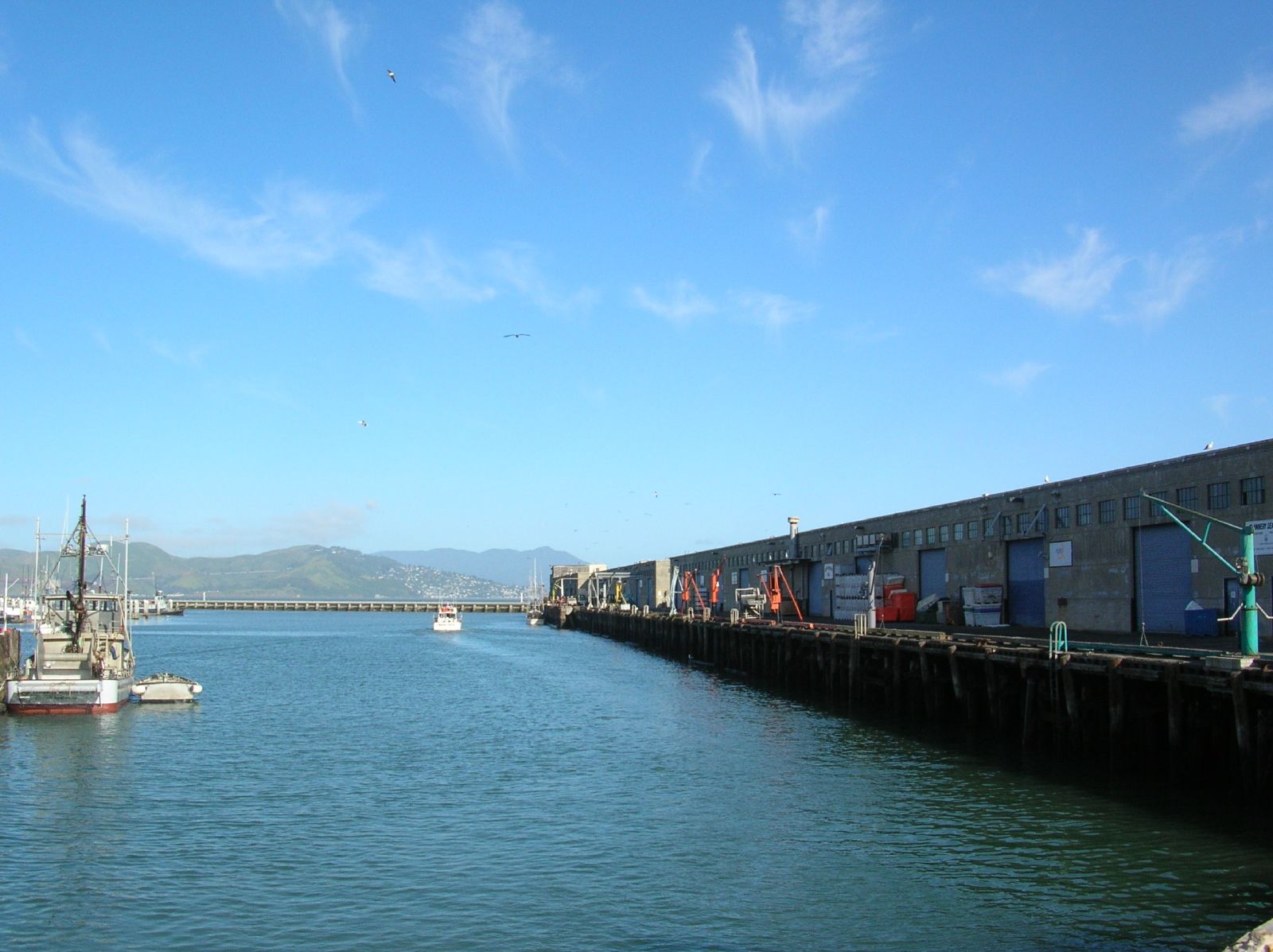 many boats floating down a river next to a dock