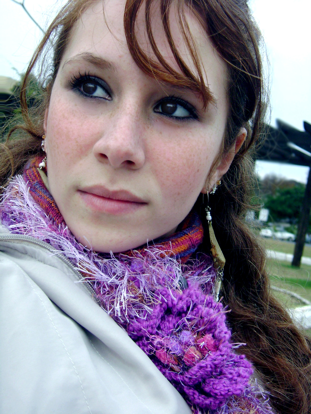 a woman with red hair has purple flowers in her collar