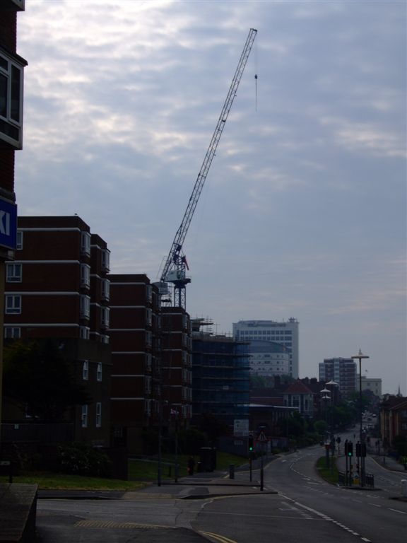 a very tall crane standing over a street