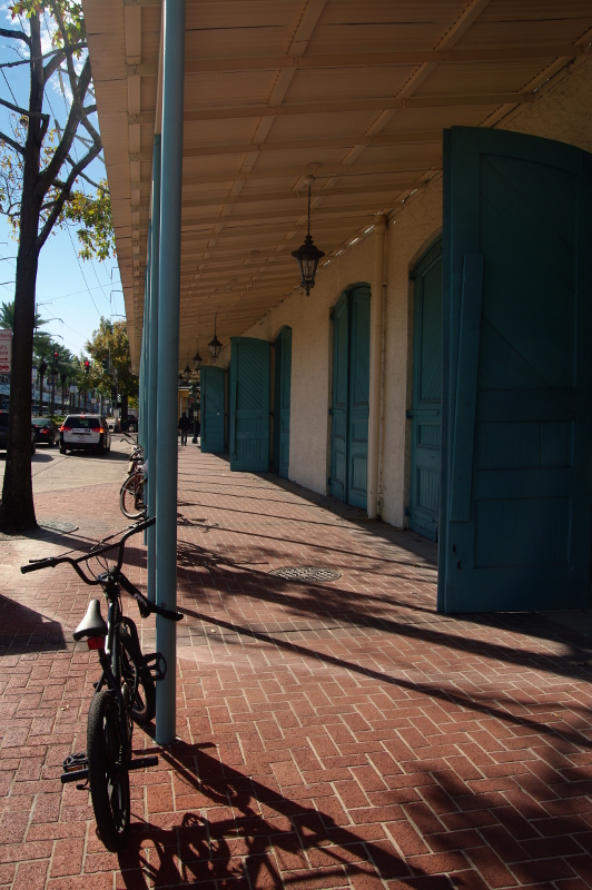 bicycle parked next to a pole with blue doors