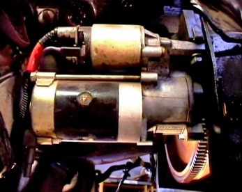 an older metal and red type of motor unit with the engine door open