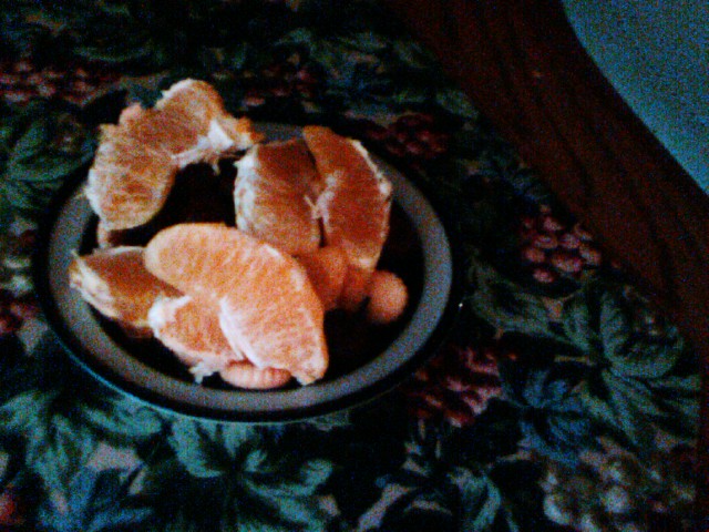 the bowl is sitting on the table full of orange slices
