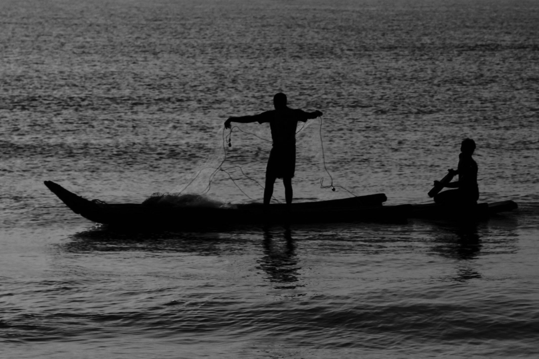 two people sitting in a boat on the water