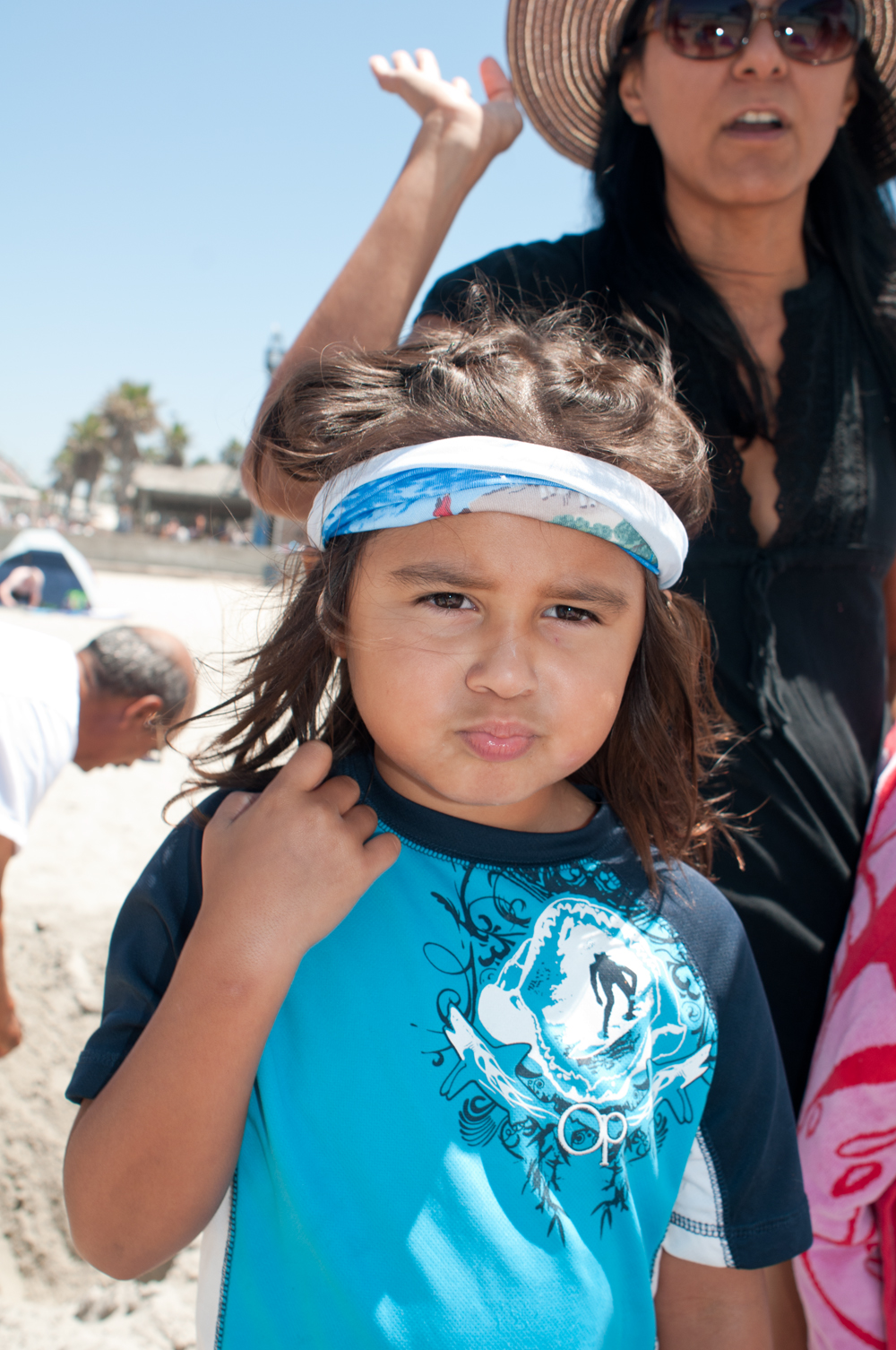 a woman holding her child while standing on the beach