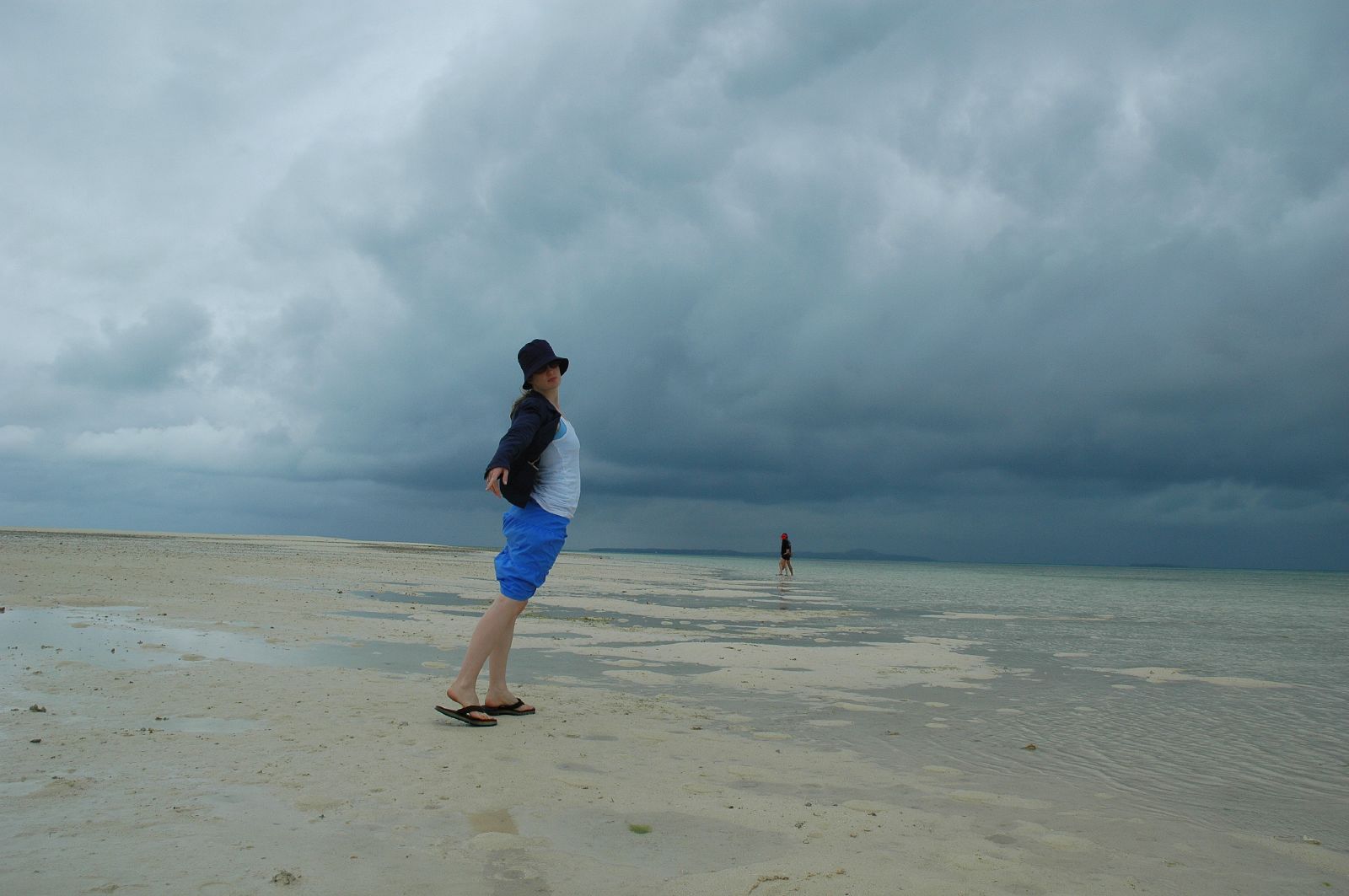 there is a man walking in the sand near the ocean