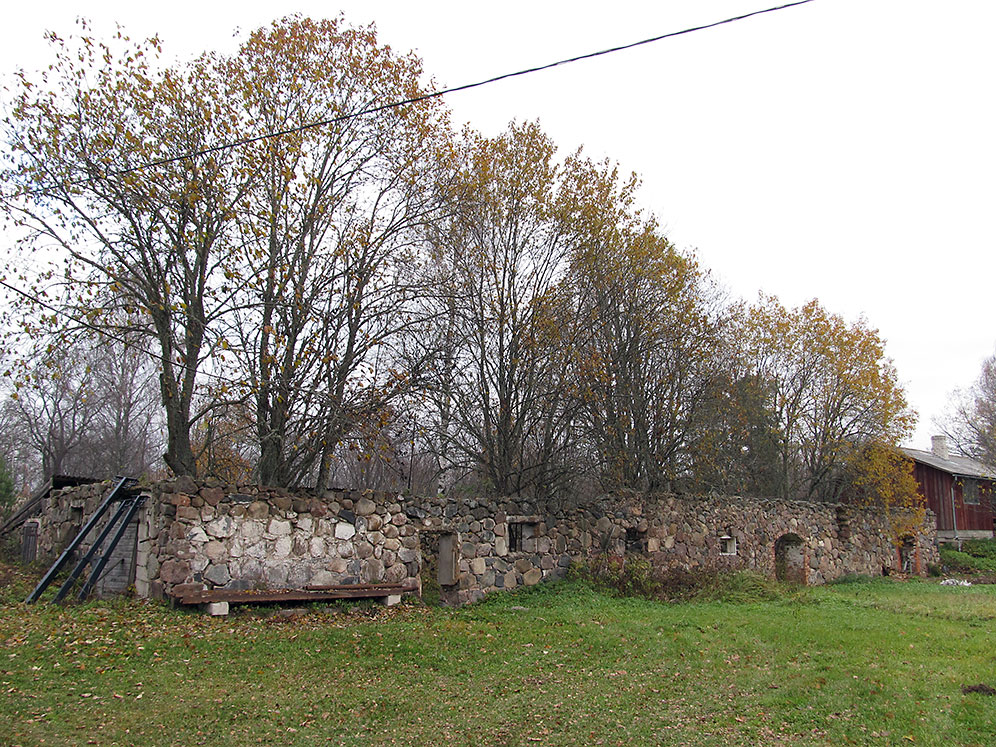 a stone wall and two buildings in the background