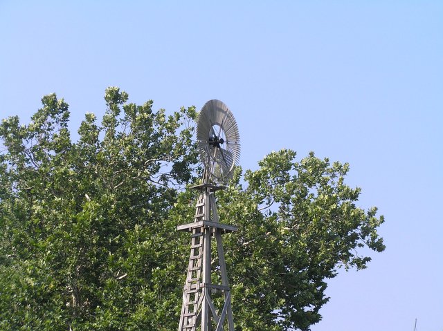 a wooden tower with a large wind indicator on top