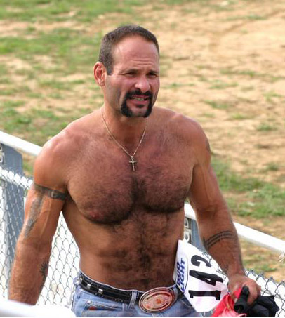 a shirtless man is seen leaning against a fence