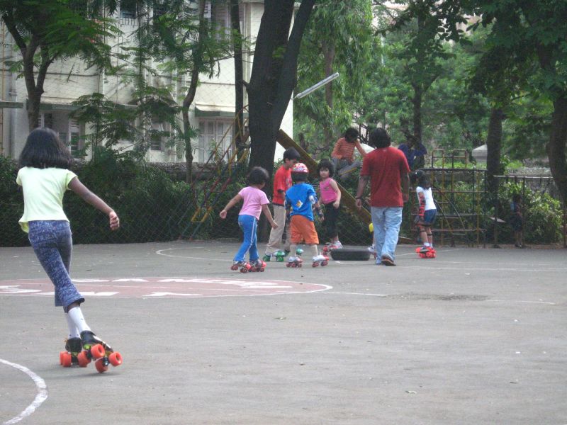 young children playing on skateboards at outdoor playground