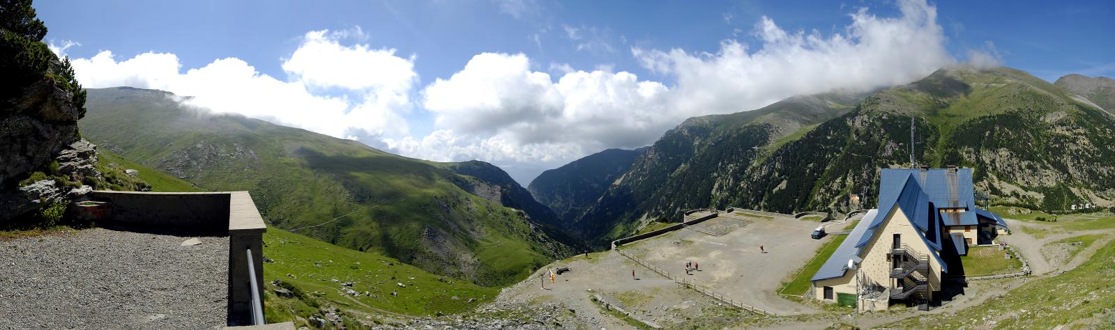 the clouds are flying above a mountainous valley